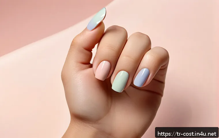 네일아트 비용 - A close-up image of a hand displaying minimalist nail art with pastel-colored nails, featuring delic...